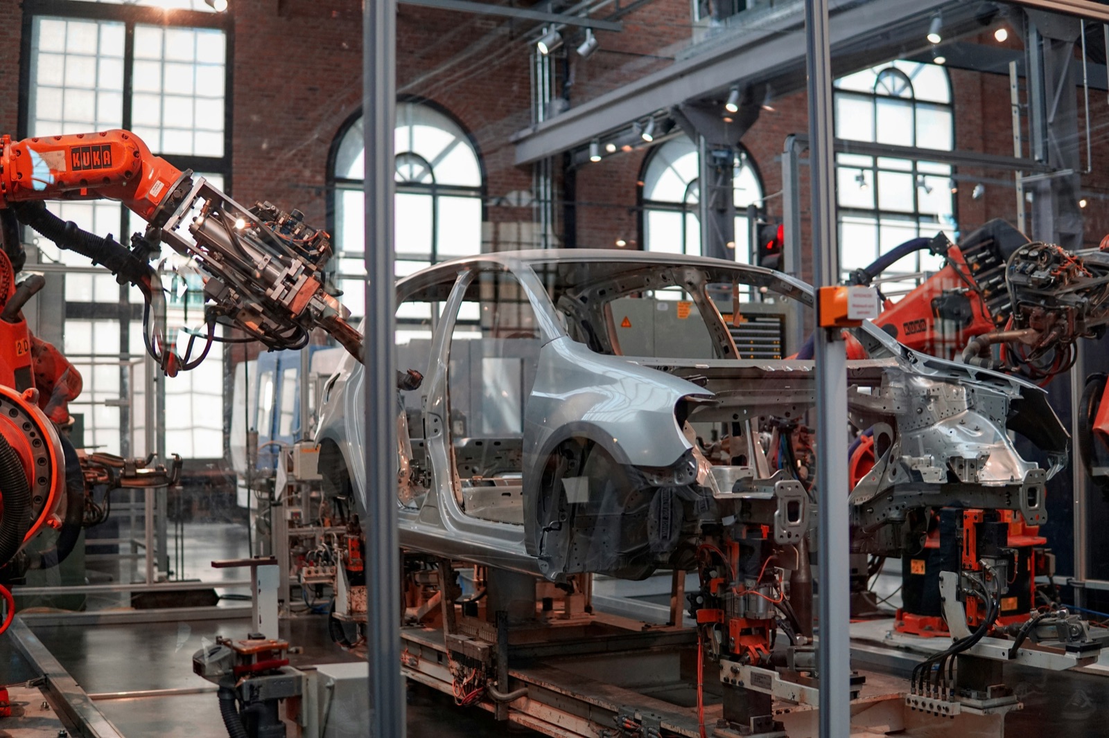 Industrial robot performing vehicle assembly for Incure CDM™ UV conveyor robotic cell integration