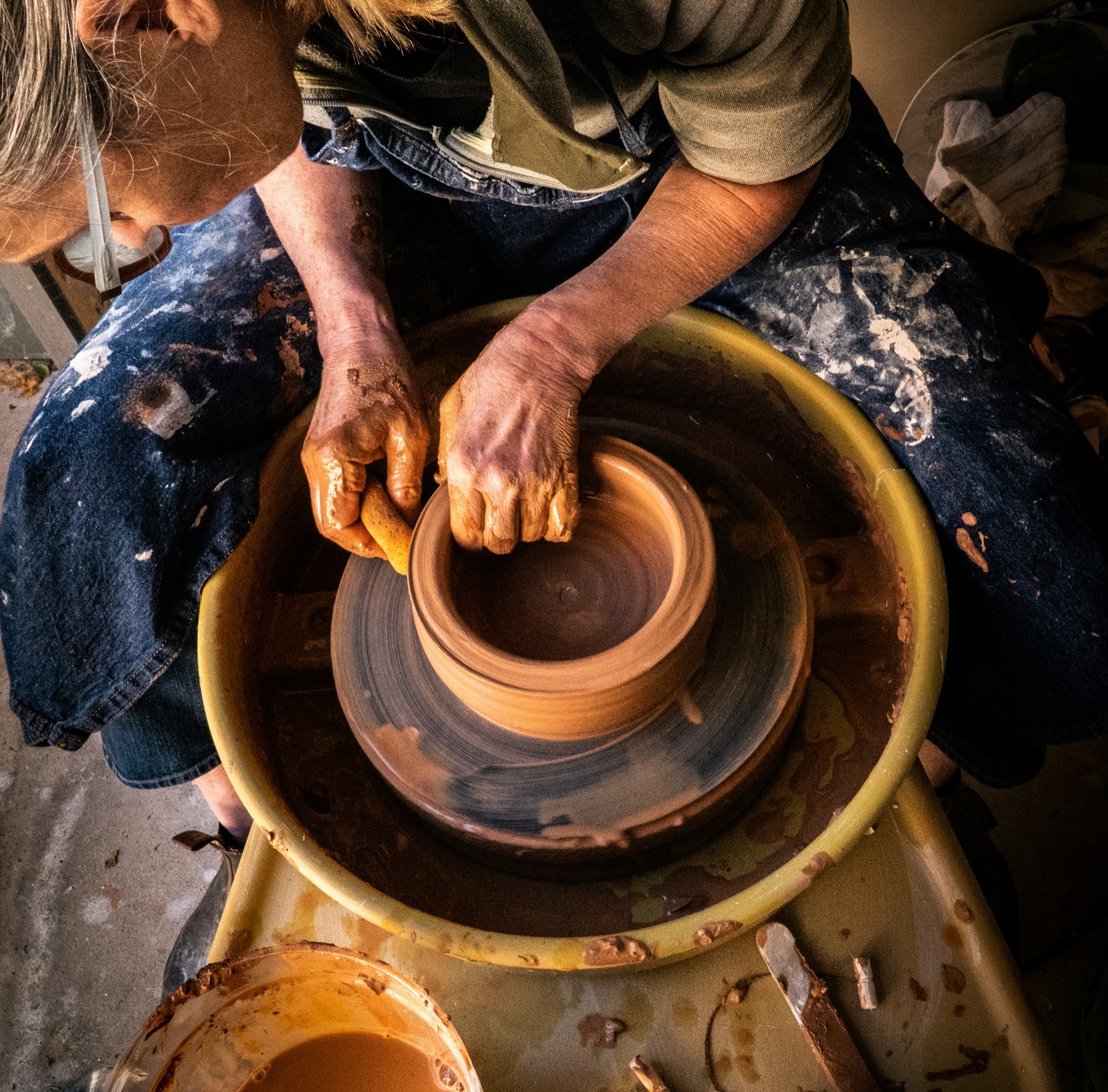 Hands shaping clay on pottery wheel in ceramic production with Epo-Weld™ HTC kiln furniture coating