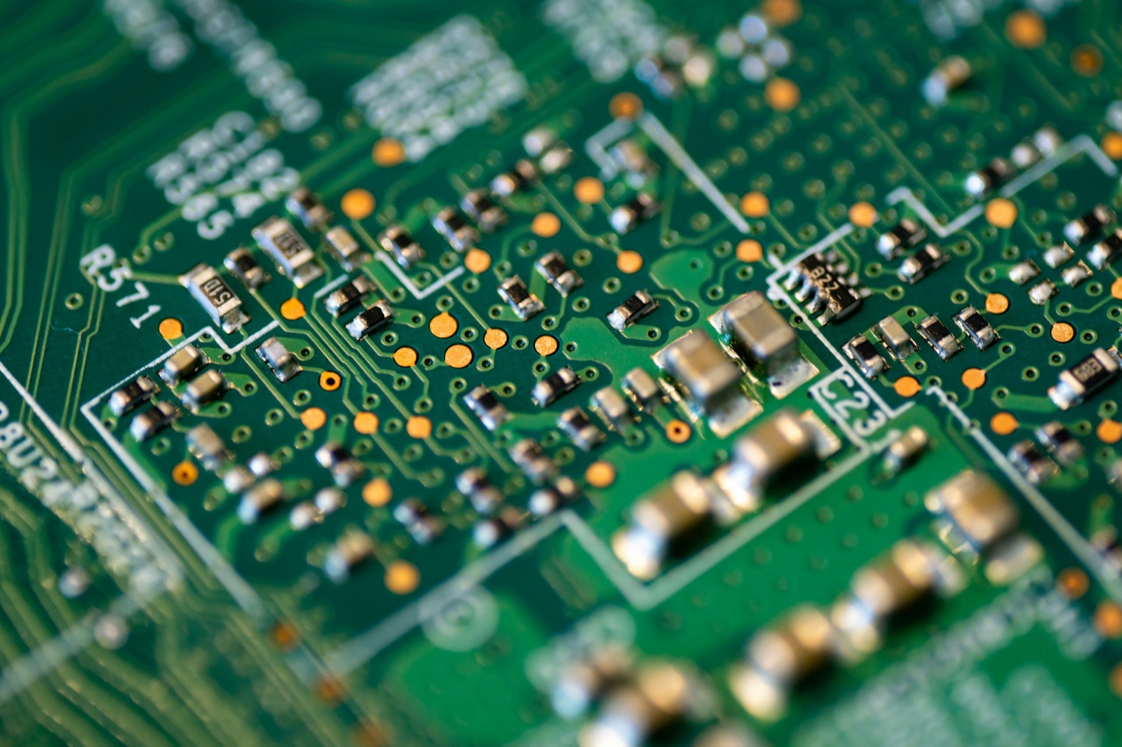 Close-up green circuit board with surface mount components for UV adhesive electronics assembly