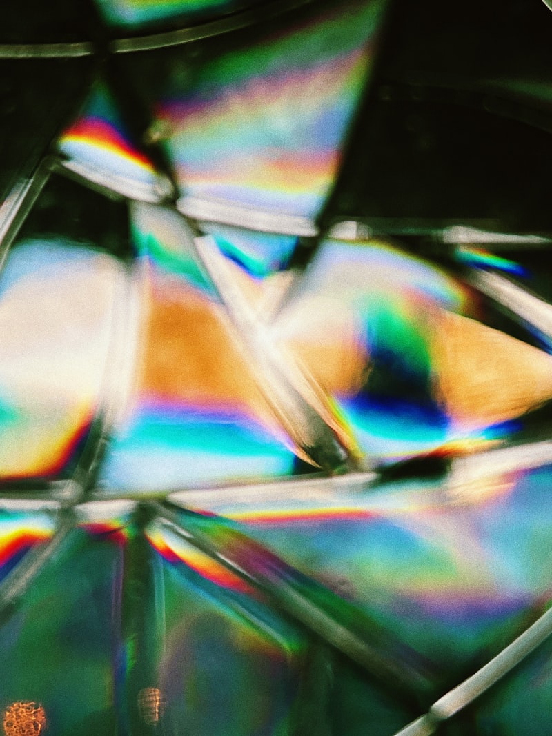 Macro photograph of glass refracting white light into rainbow spectrum for Optik™ UV prism and beamsplitter mounting